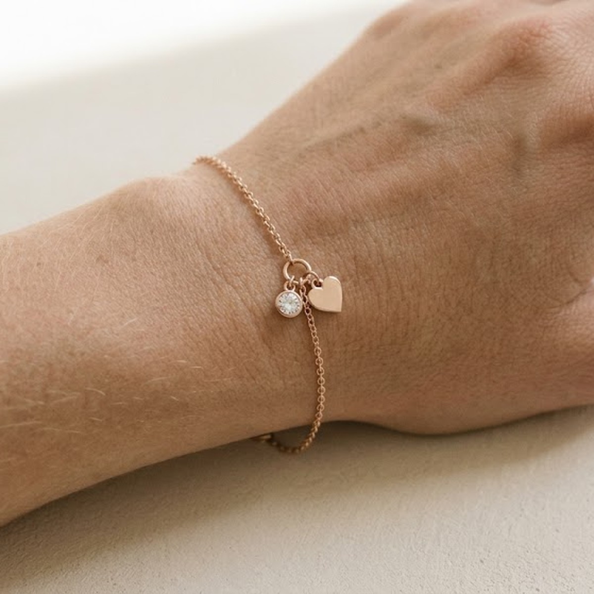 A diamond-set charm on a bracelet, worn on the wrist