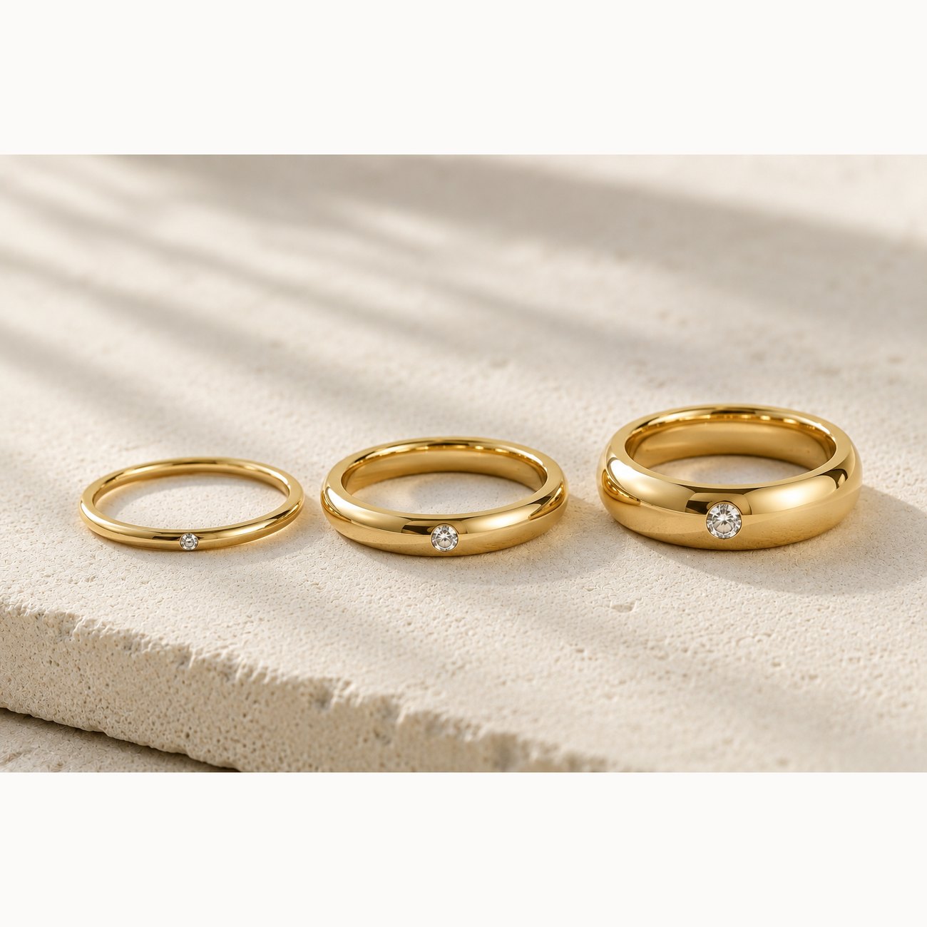 Three comfort-fit bands in fine, medium and broad widths, each flush-set with a diamond